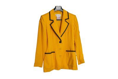 un blazer jaune avec des bordures noires, suspendu à un cintre
