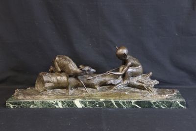 bronze statue of a boy on a log with a dog