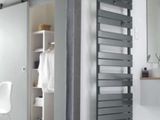 une photo d'une salle de bains avec un grand miroir et un radiateur