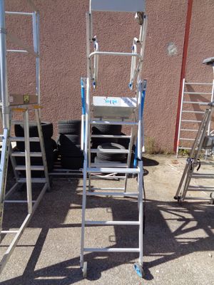 many ladders that are sitting outside of a building