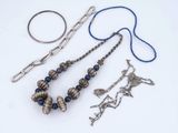 a necklace, bracelet, ring, and other jewelry on a white surface
