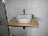 a white sink sitting on a wooden counter in a bathroom