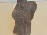 une vieille statue représentant une femme coiffée d'une couronne