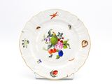 une assiette blanche décorée d'un oiseau et de fleurs