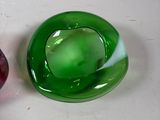 two green and red glass objects on a white surface