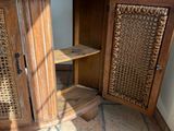 une armoire en bois avec une porte en osier, dans un coin de la pièce