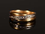 gros plan d'une bague en or avec des diamants sur une surface noire