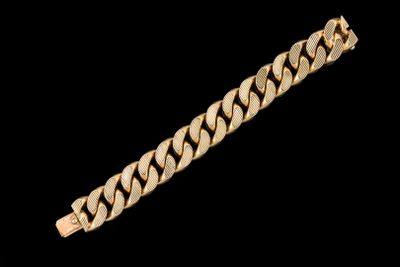 gros plan d'un bracelet en or sur fond noir