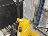 a yellow forklift sitting on a pallet in a warehouse