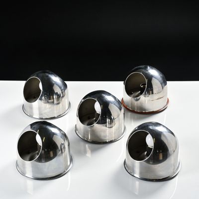 four silver metal objects sitting on top of a white table