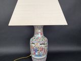 une lampe avec un abat-jour blanc posée sur une table