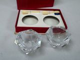 two glass ashtrays in a red box on a table