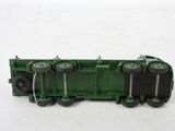 a green toy truck with wheels on a white surface