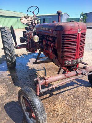 a red tractor that is sitting in the dirt
