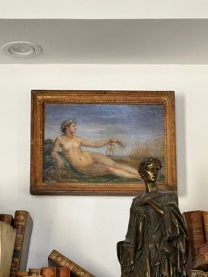 a statue of a woman sitting on a shelf next to a painting