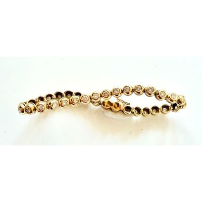 gros plan d'un bracelet en or sur une surface blanche