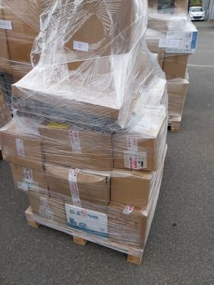 une pile de cartons emballés dans du plastique, posée sur une palette