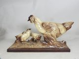 a figurine of a bird and two chicks on a table