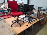 une chaise de bureau rouge posée sur un bureau dans un atelier