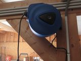 une soufflerie bleue posée sur une poutre en bois dans un garage