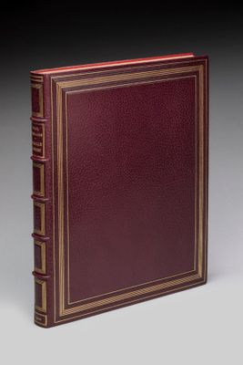 un livre en cuir rouge avec des finitions dorées et une bordure dorée