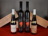three bottles of wine sit next to a wooden box on a table