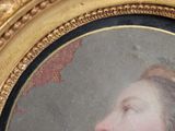 a painting of a woman in a gold frame on the wall