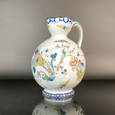a white vase with a blue and yellow design on it