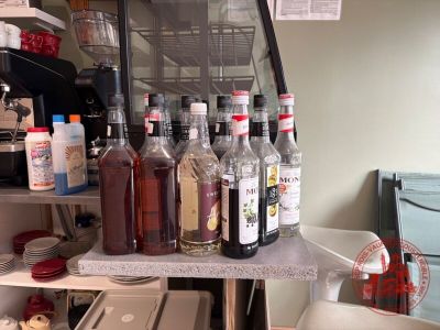 de nombreuses bouteilles d'alcool posées sur une étagère dans une cuisine