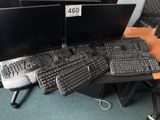 a lot of computer keyboards and monitors on the desk