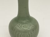 a green vase with a dragon on it on a white surface