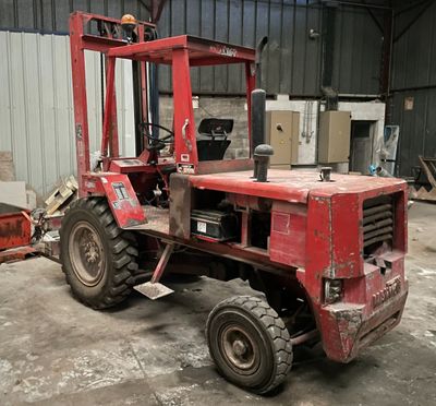 un chariot élévateur rouge garé dans un entrepôt