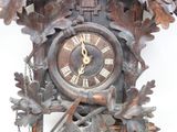 a clock that is on the wall with a bird on top of it