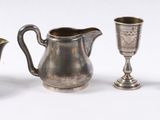 de nombreux objets en verre argenté et bleu disposés sur un fond blanc