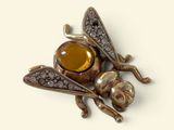 a brooch of a bee with a stone in its mouth