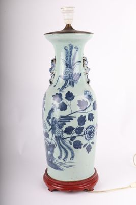 un vase bleu et blanc sur lequel est posée une lampe
