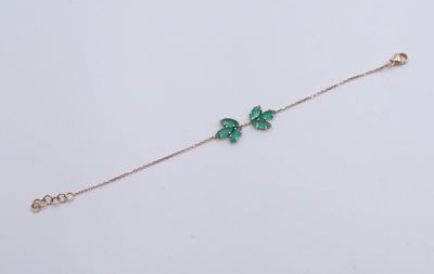 un bracelet avec un papillon vert sur fond blanc