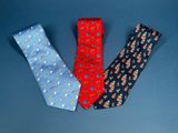 three different colored ties are arranged in a row on a blue surface
