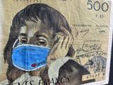 a drawing of a woman wearing a face mask on a bank note