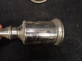 a person holding a silver cup on a black surface