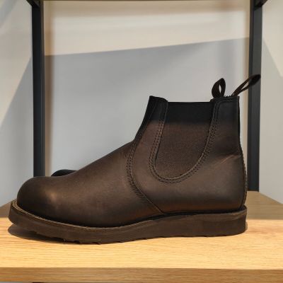 un gros plan sur une paire de bottes marron posées sur une étagère