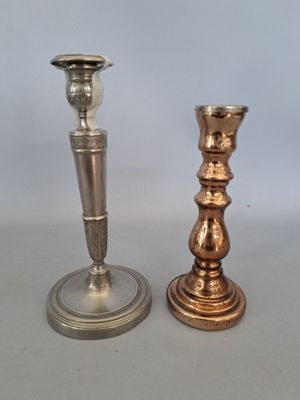deux bougeoirs en argent posés l'un à côté de l'autre sur une table
