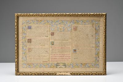 an old manuscript with a gold frame on a white table