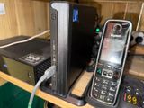 a cell phone that is connected to a charger on a shelf