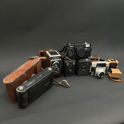 un tas de vieux appareils photo posés sur une table