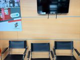 quatre chaises dans une salle d'attente avec une télévision accrochée au mur