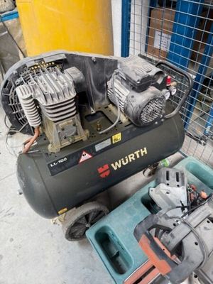 un petit compresseur d'air posé sur un chariot à côté d'autres outils