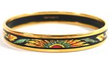 a close up of a black and gold bracelet with sunflowers on it