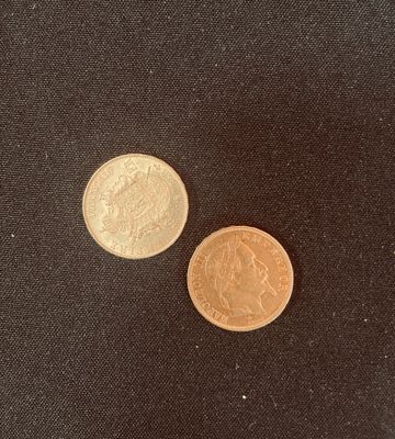 un gros plan de deux pièces de monnaie posées sur une surface noire