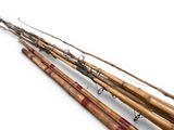 several old fishing rods are lined up on a white surface